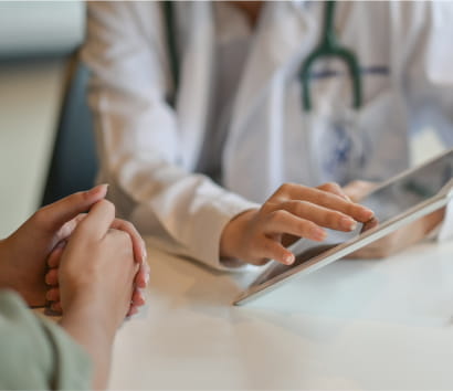 Close up of a provider showing information to a patient on a digital tablet.